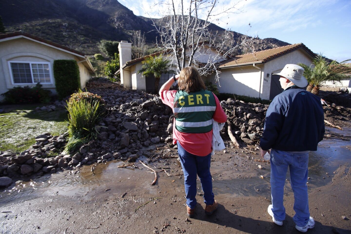 Barbara Williams, left, president of the homeowners association, and resident Barry Gilbert view the debris flow in Camarillo Springs.