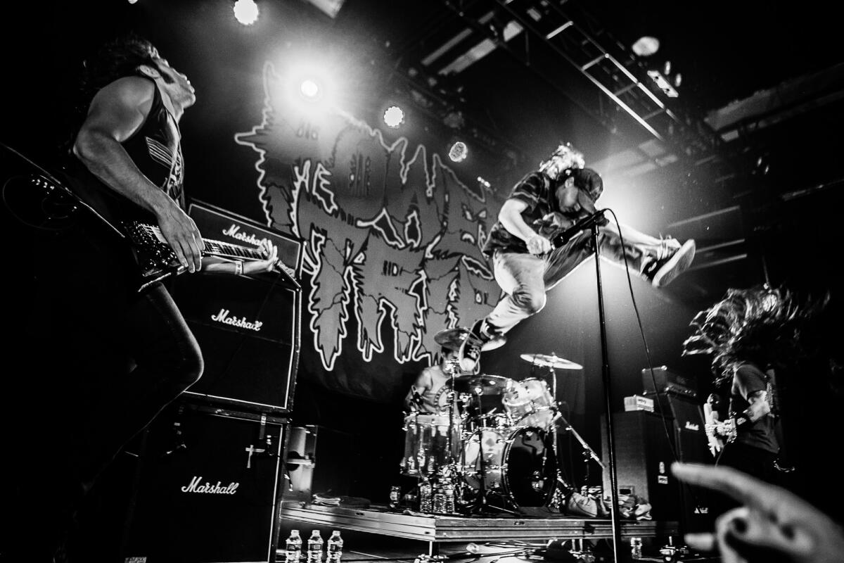 Riley Gale leaps into the air while performing with his band.