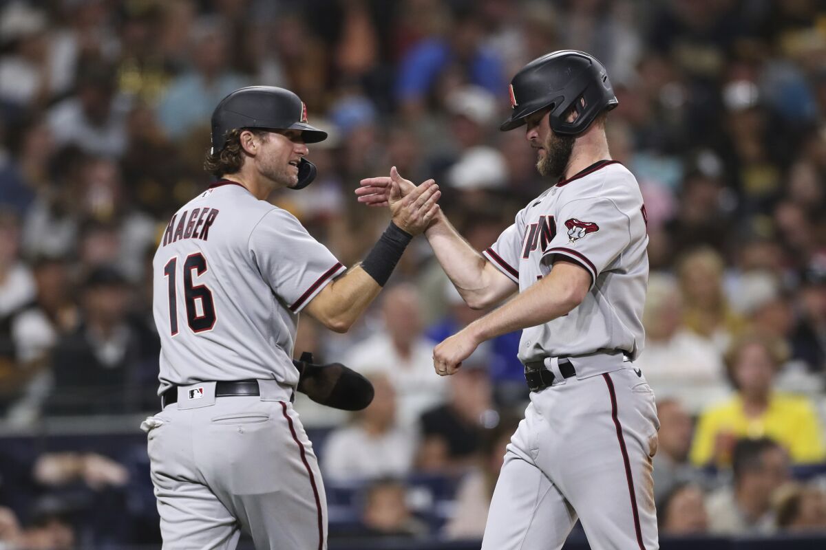 Arizona Diamondbacks' Jake Hager, left, celebrates with Matt Peacock after they scored on a single by Nick Ahmed against the San Diego Padres during the fourth inning of a baseball game Friday, Aug. 6, 2021, in San Diego. (AP Photo/Derrick Tuskan)