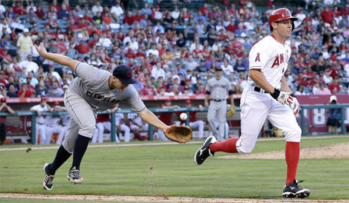 Cleveland pitcher Justin Masterson, left, tosses the ball to first baseman Nick Swisher for the out on Angels center fielder Peter Bourjos, right, during the seventh inning of the Indians' victory, 3-1.