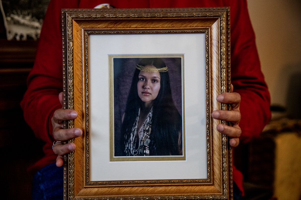 A woman holds a photograph of her daughter, who disappeared in October 2021 on the Yurok reservation.