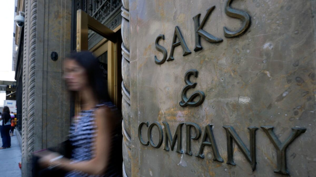 In this file photo, a shopper uses a Fifth Avenue entrance to Saks, in New York. A data breach at department store chains Saks Fifth Avenue, Saks Off Fifth and Lord & Taylor has compromised customers' personal information.