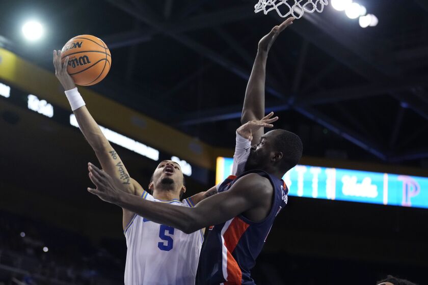 UCLA guard Amari Bailey (5) shoots over Pepperdine forward Boubacar Coulibaly during the second half of an NCAA college basketball game Wednesday, Nov. 23, 2022, in Los Angeles. (AP Photo/Marcio Jose Sanchez)