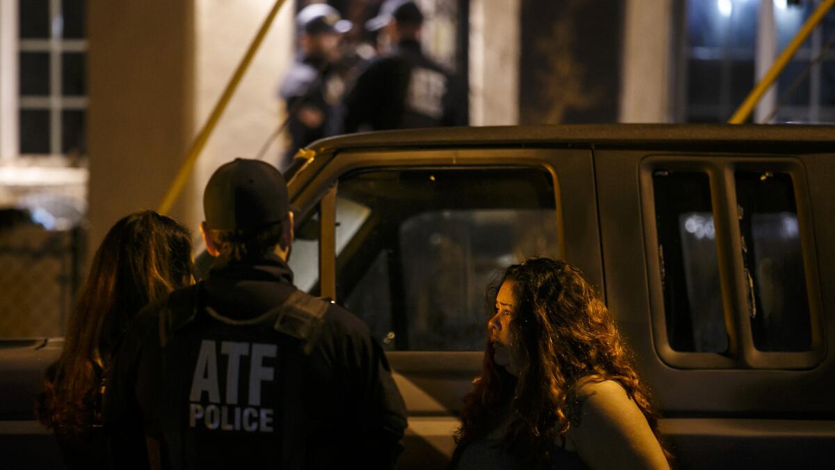 ATF agents speak to a suspect in handcuffs during a house raid in the San Fernando Valley on Nov. 2, 2016.