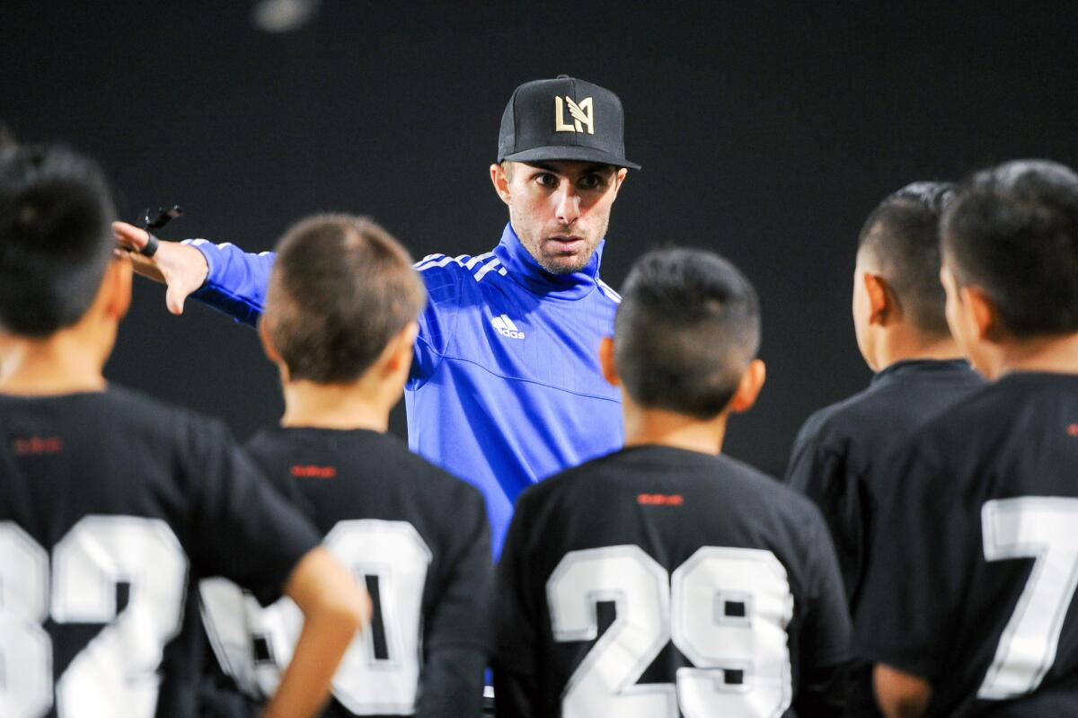 Coach Joey Cascio talks to children at a Los Angeles Football Club soccer academy practice at Cal State L.A. All the participants wear jerseys with numbers higher than 26 until a 26-man roster is chosen.