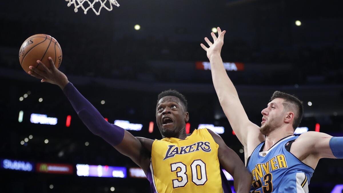 Lakers forward Julius Randle tries to score inside against Nuggets center Jusuf Nurkic during their preseason game Friday night at Staples Center.