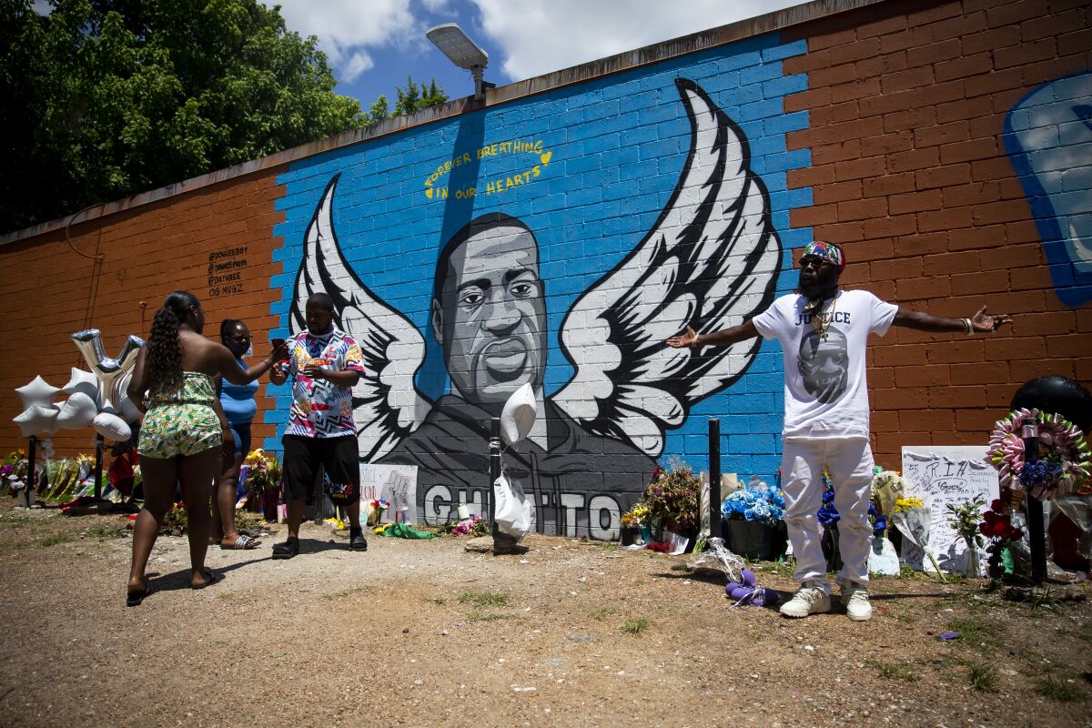 OG Bezel, right, joins other visitors at the mural honoring George Floyd in the Third Ward in Houston on June 7, 2020.