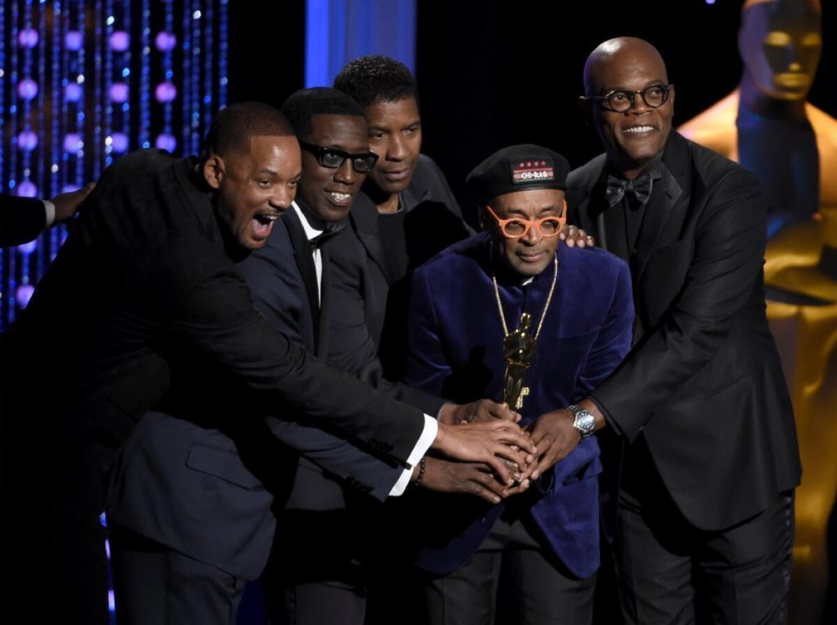 From left, Will Smith, Wesley Snipes, Denzel Washington and Samuel L. Jackson congratulate filmmaker Spike Lee (in glasses) on his honorary Oscar.