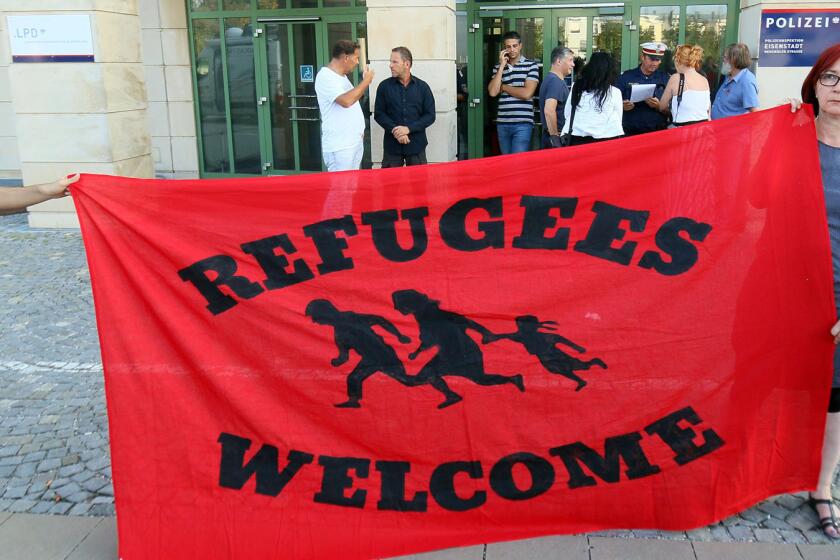 Migrant supporters hold a banner in front of the police station in Eisenstadt, Austria, on Thursday.
