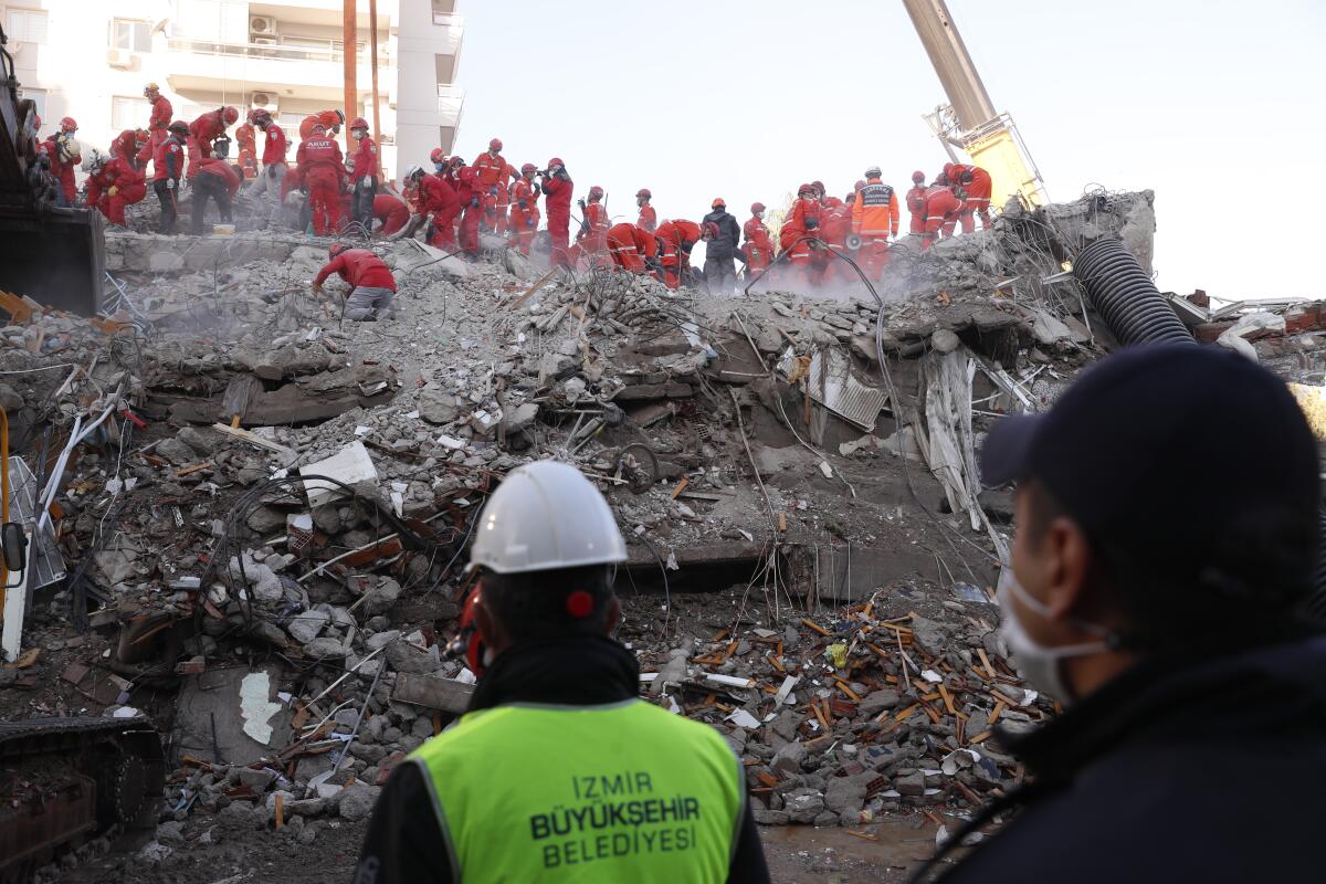 A goup of rescuers works amid the rubble of a building in Izmir, Turkey.