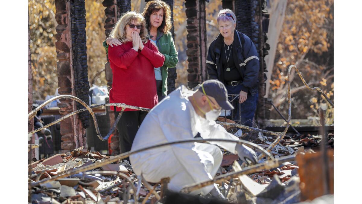 Shepha Schneirsohn Vainstein, left, and her sister Karen Sorensen watch as archeologist Michael Newland sifts through rubble to recover the cremated remains of their mother.