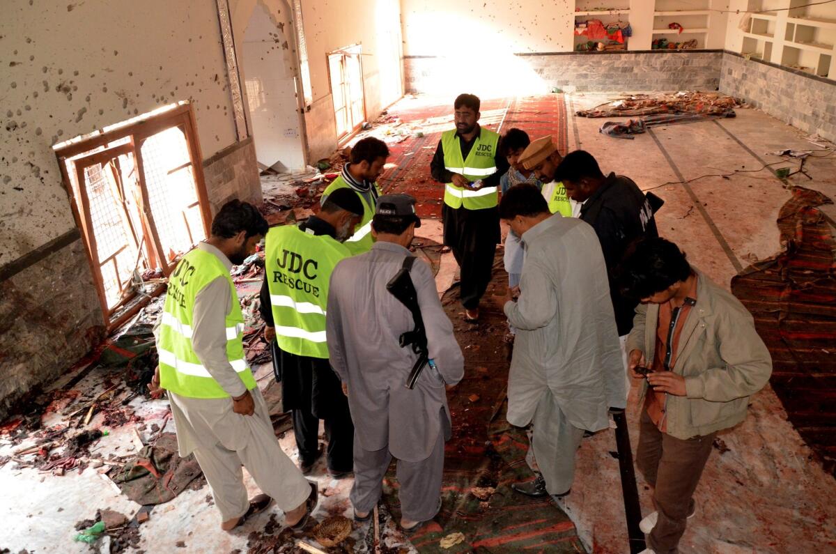 Pakistani investigators and security officials look for evidence at a Shiite Muslim mosque in Shikarpur, Pakistan on Jan. 30.