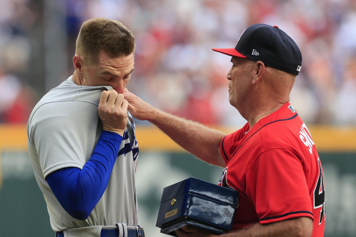 Dodgers' Freddie Freeman reacts emotionally as he is presented his World Series ring by Braves manager Brian Snitker.
