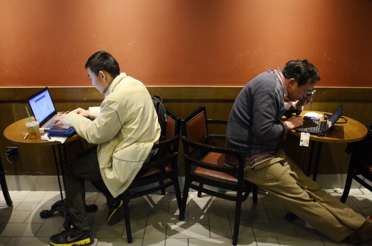 Men use their laptops at a cafe in Beijing. A 16-year-old schoolboy was arrested last week under a controversial new Chinese crime of spreading rumors over the Internet.