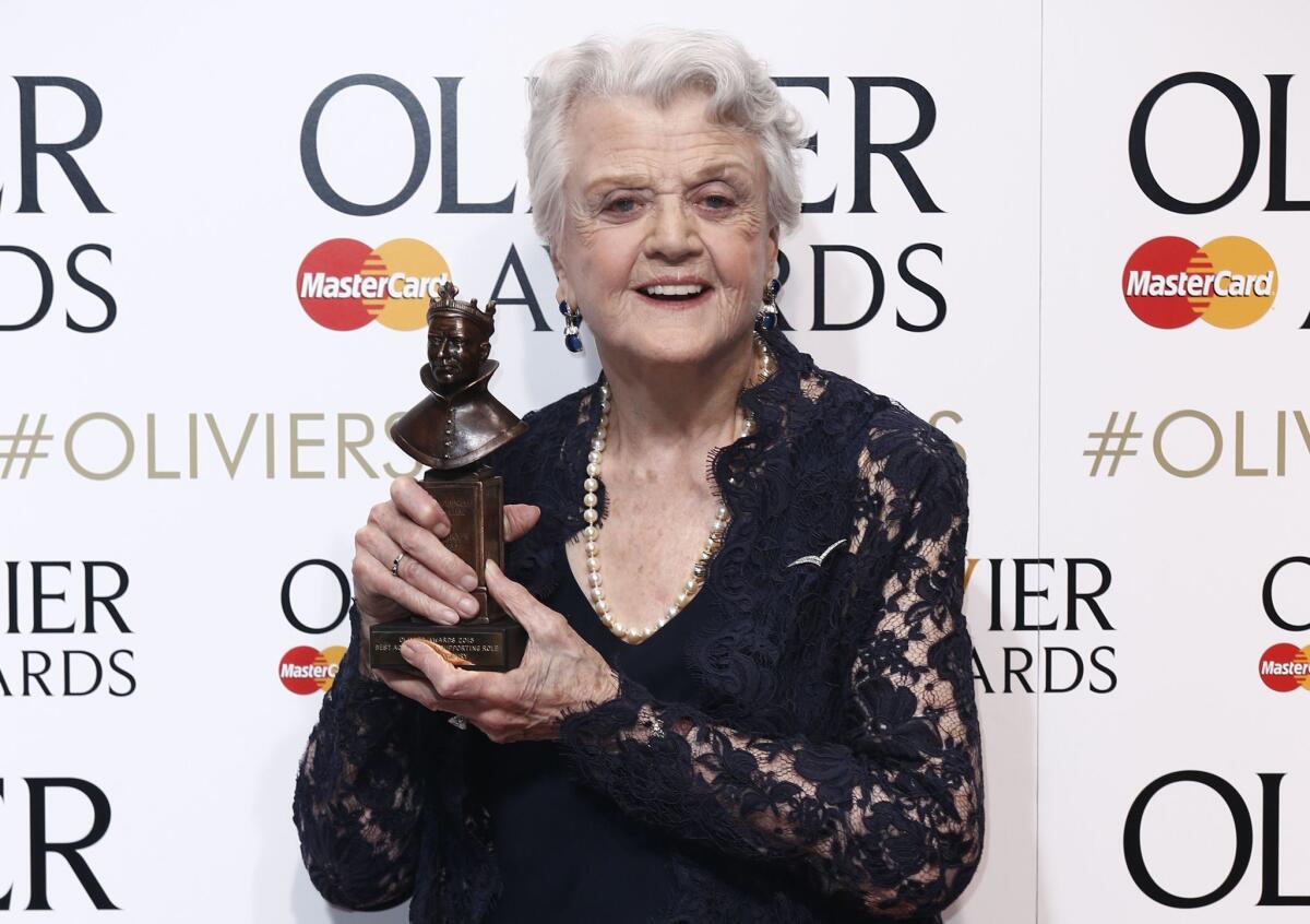 Angela Lansbury shows off her supporting actress award for "Blithe Spirit" during the Lawrence Olivier Awards in London on April 12.