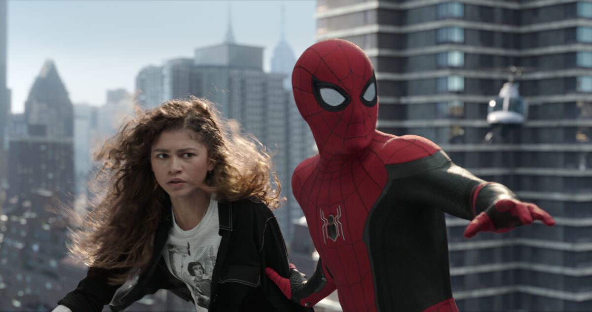 A woman and a man in a Spider-Man suit against a city skyline