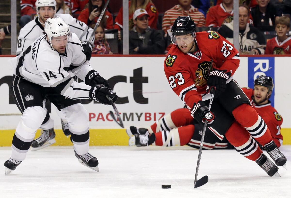Chicago Blackhawks right wing Kris Versteeg, right, controls the puck in front of Kings right wing Justin Williams during the second period of the Kings' 3-1 loss Sunday.