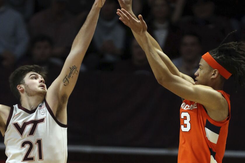 Syracuse's Benny Williams (13) right, has his shot tipped by Virginia Tech's Grant Basile (21) during the first half of an NCAA college basketball game Saturday, Jan. 28, 2023, in Blacksburg, Va. (Matt Gentry/The Roanoke Times via AP)