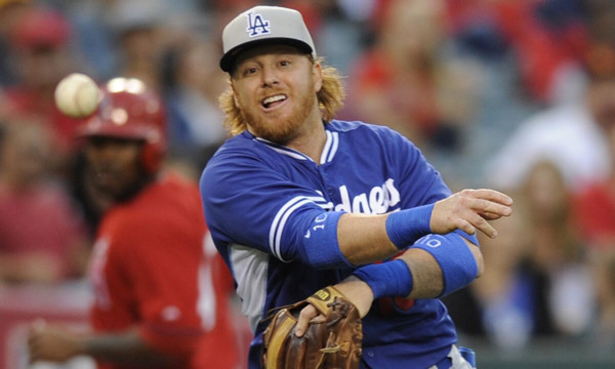 Dodgers second baseman Justin Turner throws to first base during the second inning of the team's 6-2 exhibition loss to the Angels on Saturday.