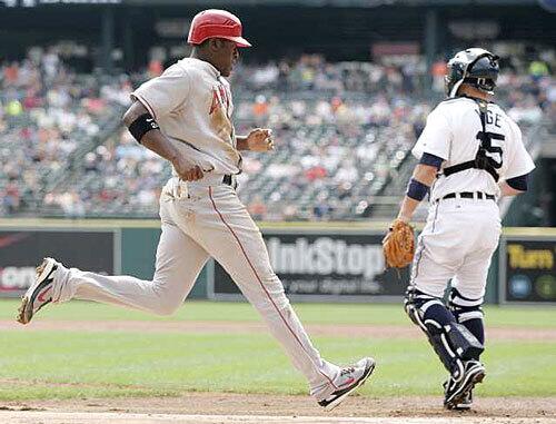 Angels' Gary Matthews Jr., left, scores past Tigers' catcher Brandon Inge on a single by Mark Teixeira in the third inning.