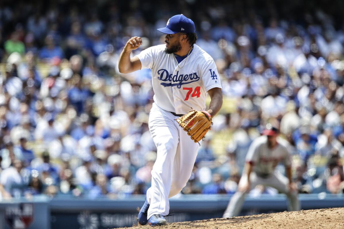 Los Angeles Dodgers reliever Kenley Jansen carries his daughter