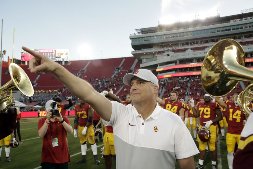 USC coach Clay Helton signals to fans after a 52-35 win over UCLA on Nov. 23, 2019.