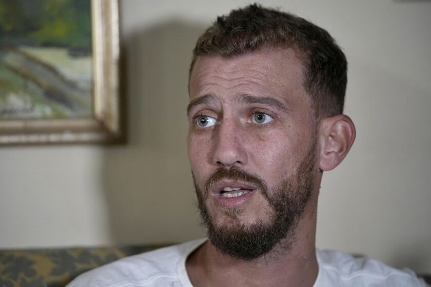 Jihad Michlawi, de 31 años, habla con la Associated Press en su casa en un suburbio de Beirut, martes 27 de setiembre de 2022. Michlawi sobrevivió al naufragio de una embarcación de migrantes en el que murieron 94 personas. (AP Foto/Bilal Hussein)