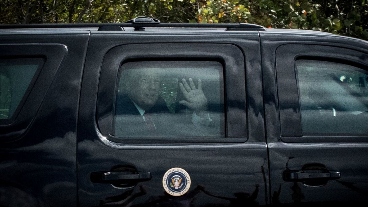 President Donald Trump waves to supporters as the presidential motorcade crosses Bingham Island in Palm Beach, Fla., on the way to Palm Beach International Airport on April 16.