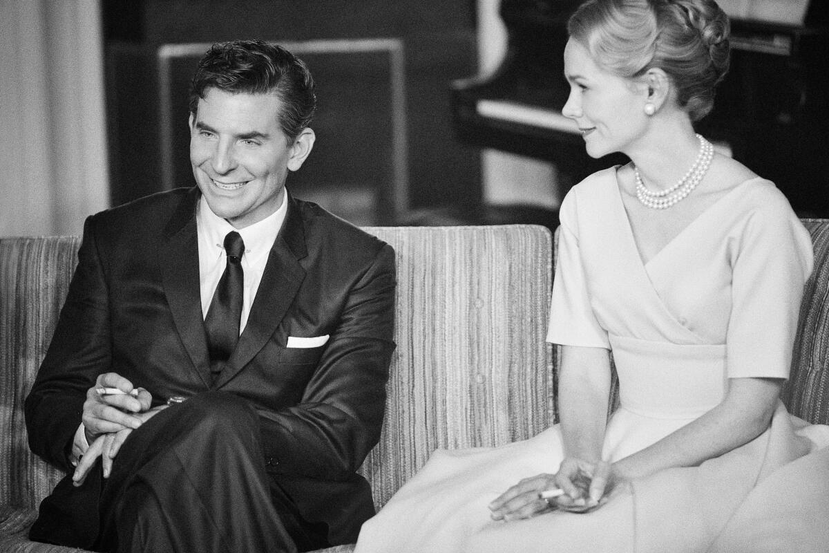 Man en vrouw zitten op de bank in een zwart-witfilmscène.
