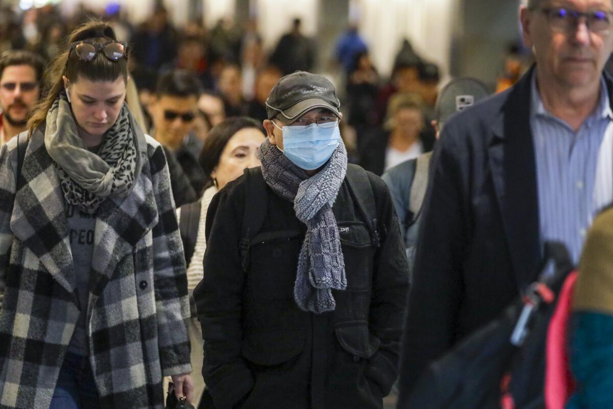 Some commuters at Union Station in downtown Los Angeles wear protective masks.