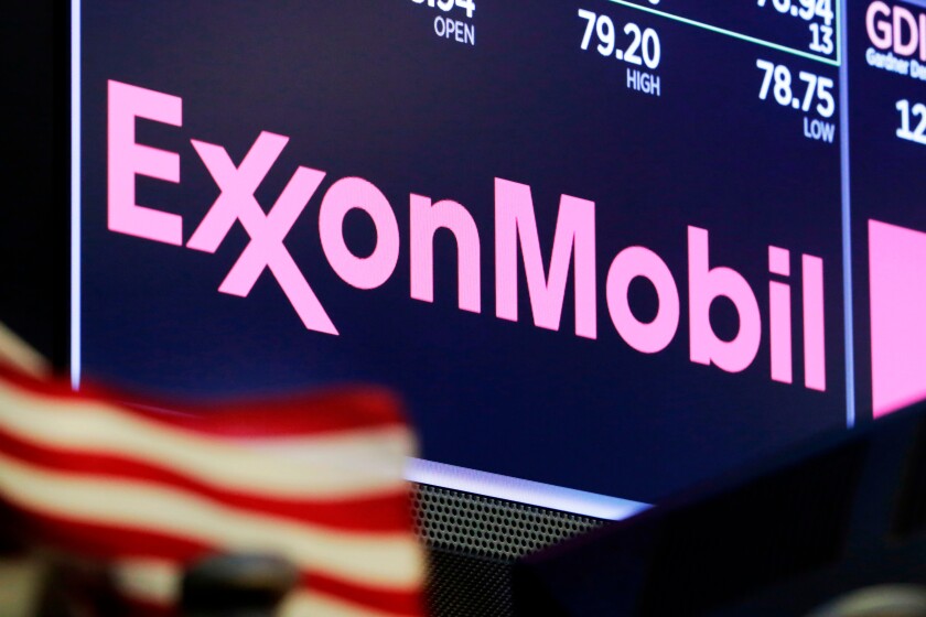 The logo for ExxonMobil appears above a trading post on the floor of the New York Stock Exchange. 