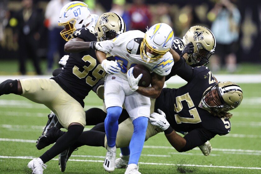 Chargers wide receiver Trevon Bradford is tackled by three Saints players.