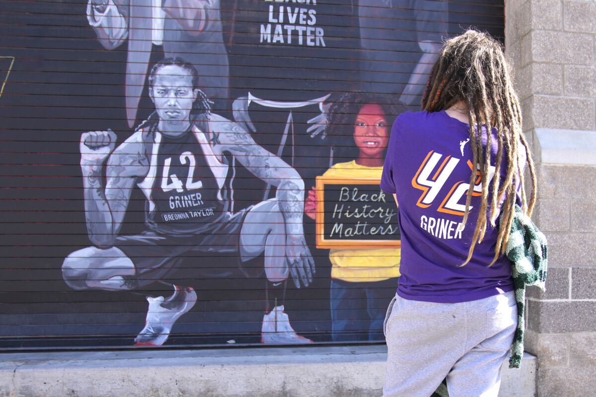 Carly Givens of Phoenix looks at a mural of Brittney Griner in Phoenix on Thursday.