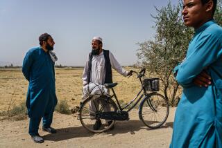 PULI ALAM, AFGHANISTAN -- SEPTEMBER 11, 2021: Nasratullah Raihan, 24, talks to passerby out in the open road near the village of Kulangar, near Puli Alam, Afghanistan, Saturday, Sept. 11, 2021. OFor the 20 years that America was here, it was problems,O he said, to the nods of others. OPlanes, missiles, rockets N all of it was here. Every day you had people killed.O (MARCUS YAM / LOS ANGELES TIMES)
