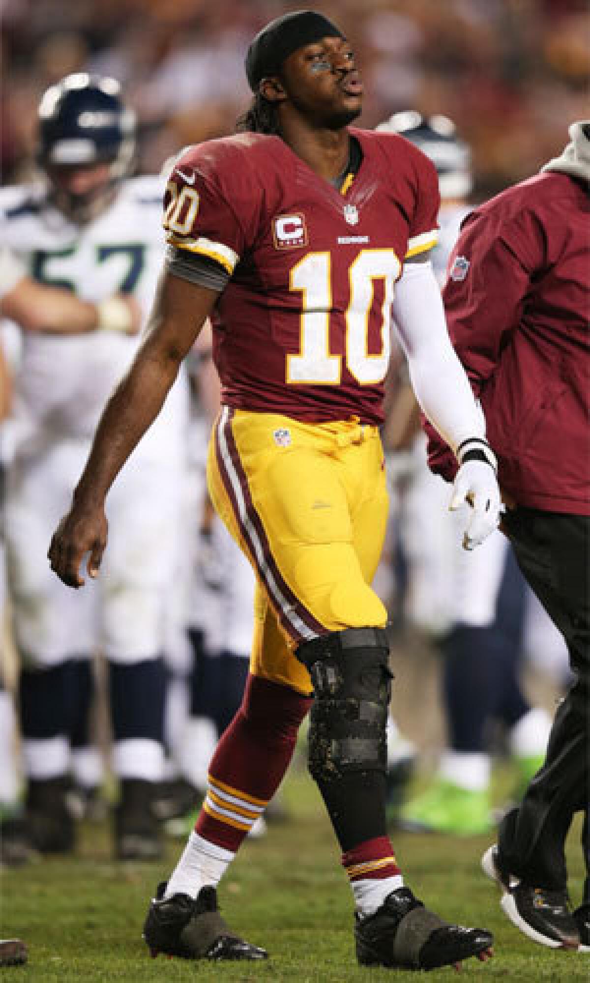 Washington quarterback Robert Griffin III leaves the field injured during the Redskins' 24-14 loss to Seattle on Sunday.