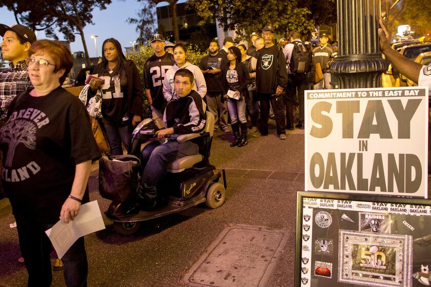 Raiders fans wait in line to enter a hearing with NFL executives at Paramount Theatre in Oakland regarding the possible relocation of the team to L.A.