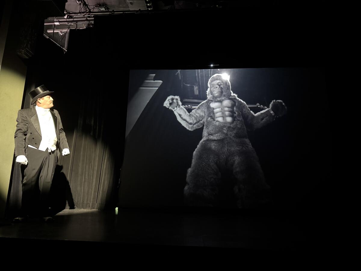 Carl Denham (Mark Coyan) watches as King Kong (Rob Downs) appears as he did in a famous scene from the vintage film.