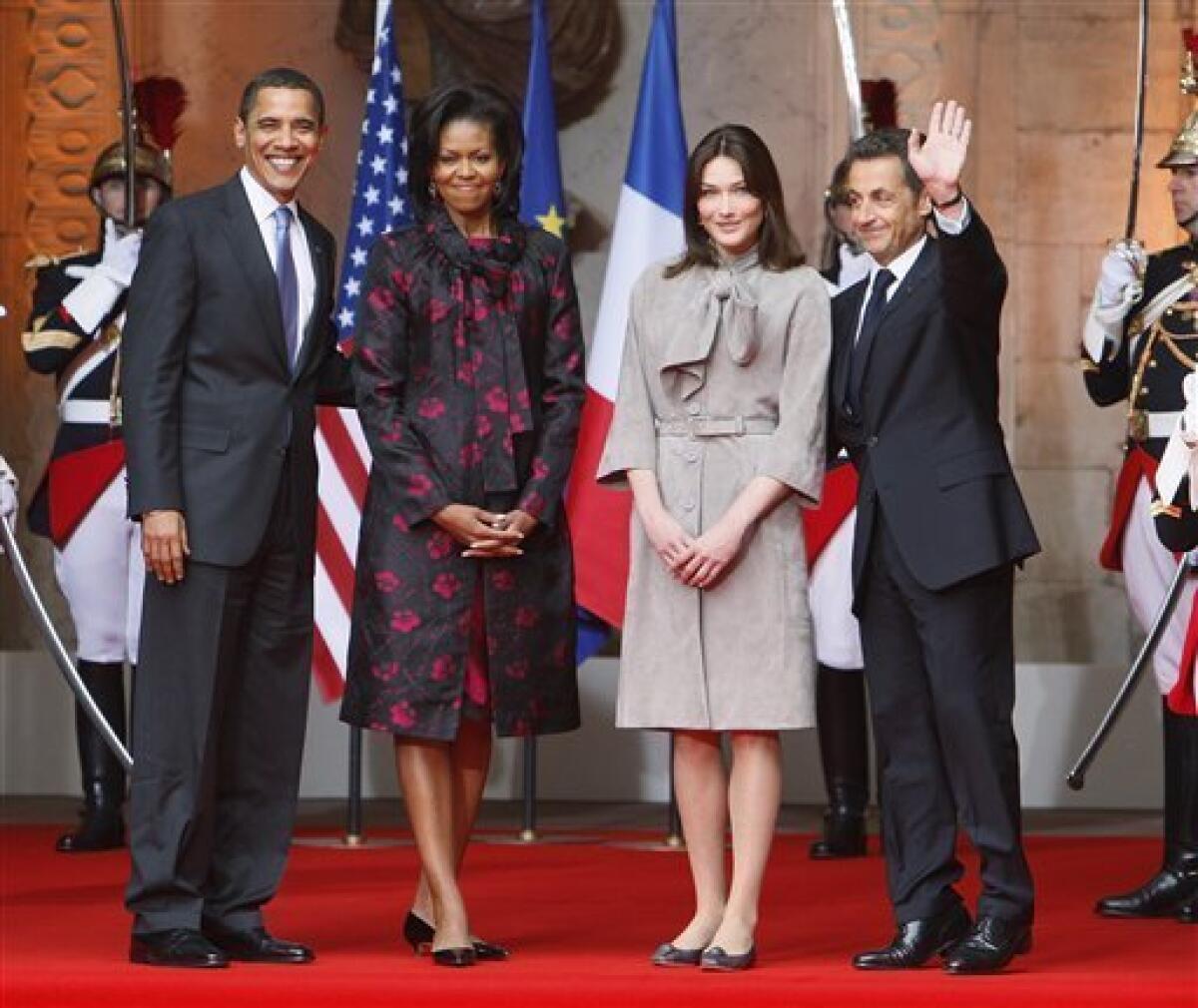 FILE - In this April 3 2009 file photo, President Barack Obama and first lady Michelle Obama are greeted by France's President Nicolas Sarkozy and wife Carla Bruni-Sarkozy at Palais Rohan in Strasbourg. From elevator shoes, to step-up boxes behind podiums, and even his own tippy-toes, Nicolas Sarkozy and his handlers have endeavored to compensate for his relatively short height. Now, a factory worker's allegation to a Belgian TV crew that she was chosen as a backdrop extra at a Normandy plant that he visited because she was short is making waves as an Internet video over a subject long sensitive for the French president. (AP Photo/Charles Dharapak, Files)