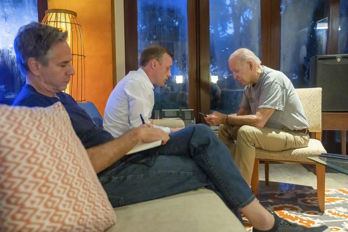 President Biden and two other men sit in a room 