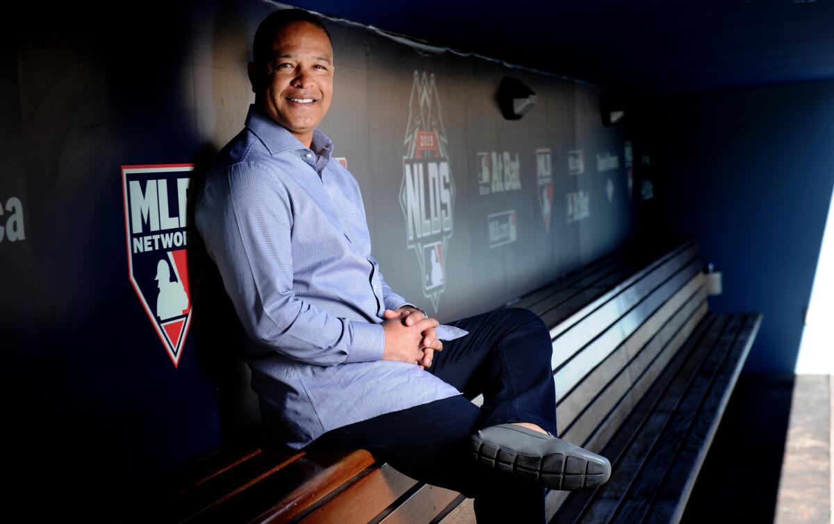 New Dodgers Manager Dave Roberts sits in the dugout before the start of the 2016 season.