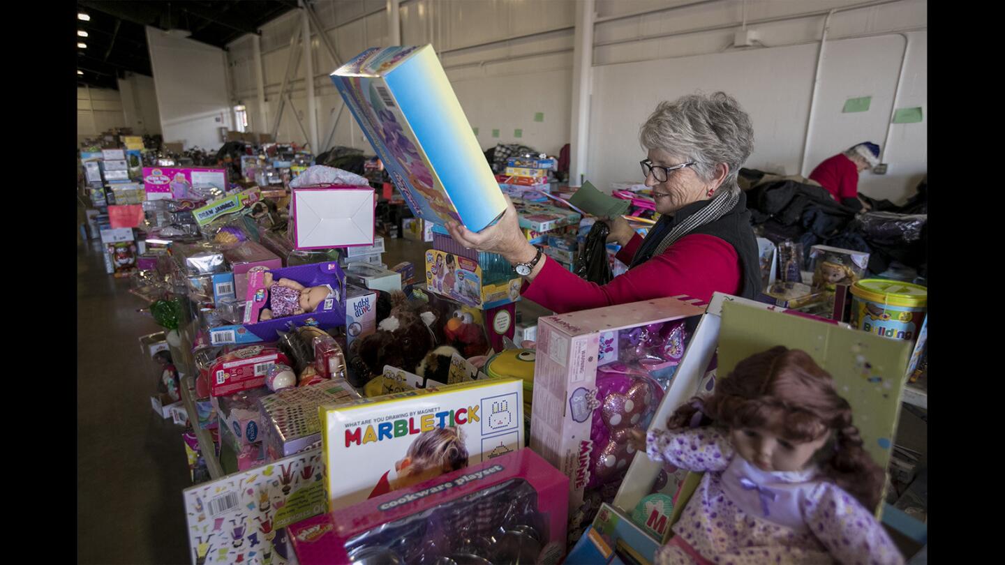 Molly Pritchard picks out a toy donated for a child during the Share Our Selves Adopt A Family program at the the OC Fair & Event Center in Costa Mesa on Tuesday. The 48th annual event connected donors with more than 1,500 Orange County families in need.