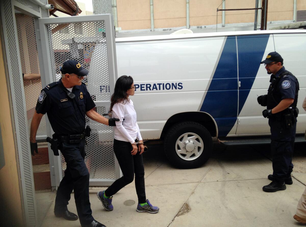 Immigration rights activist Lulu Martinez is handcuffed and led into a van by U.S. Customs and Border Protection agents in Nogales, Ariz., on Monday.