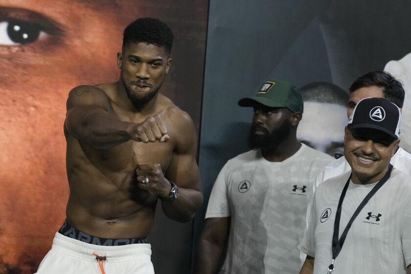 FILE - Heavyweight boxer Britain's Anthony Joshua, left, gestures during the weigh-in at King Abdullah Sports City in Jeddah, Saudi Arabia, Friday, Aug. 19, 2022. Joshua has been facing a new reality in recent months. He has been the poster boy of boxing’s heavyweight division for so long but suddenly the British fighter is on the outside looking in. His star has fallen in the wake of back-to-back losses to Oleksandr Usyk that have led many to question Joshua’s ability even as a two-time world champion. (AP Photo/Hassan Ammar, File)