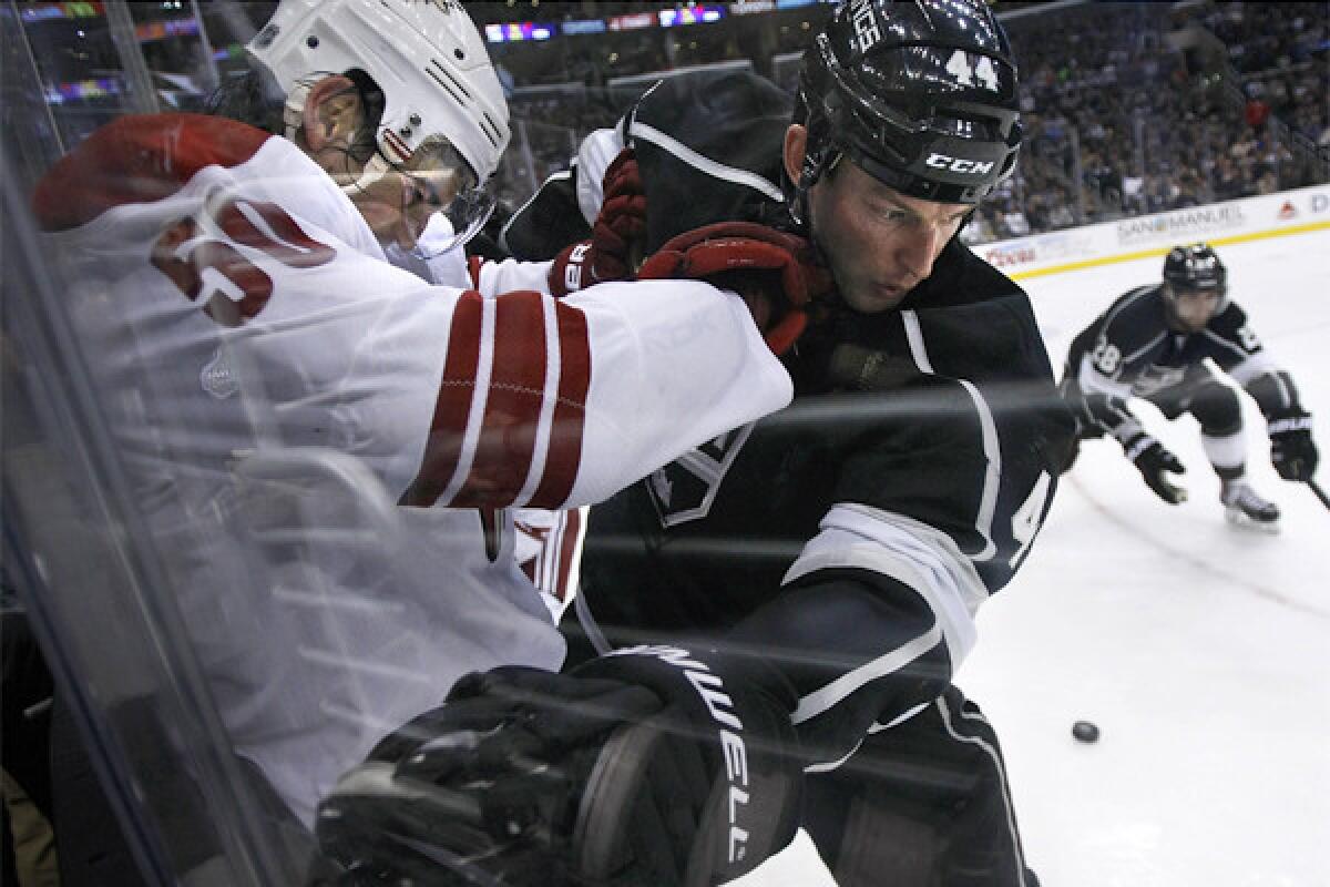 Kings' Robyn Regehr, right, battles Phoenix's Antoine Vermette on the boards on April 2.