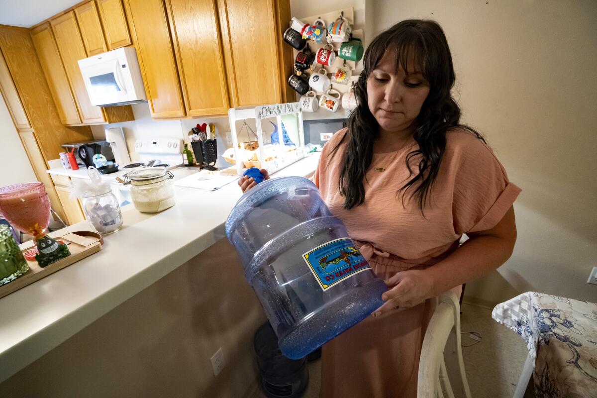 Richelle Dietz holds an empty five-gallon water bottle at her home.