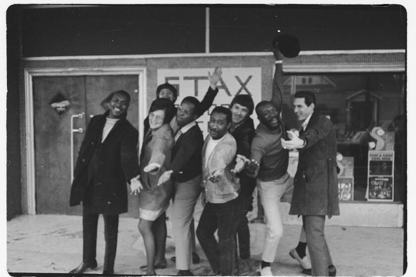 A group of musicians pose outside Stax Records. 