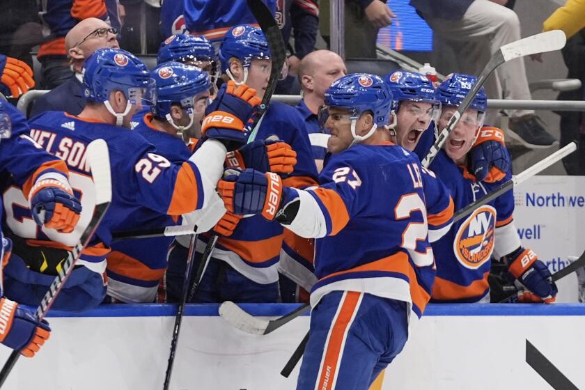 New York Islanders' Anders Lee (27) celebrates with teammates after scoring an empty net goal during the third period of an NHL hockey game against the New York Rangers Tuesday, April 9, 2024, in Elmont, N.Y. (AP Photo/Frank Franklin II)