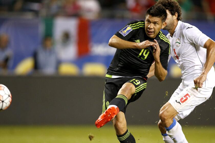 Mexico forward Oribe Peralta scores in front of Cuba defender Jorge Luis Clavelo in the first half of a Gold Cup game on Thursday night in Chicago.