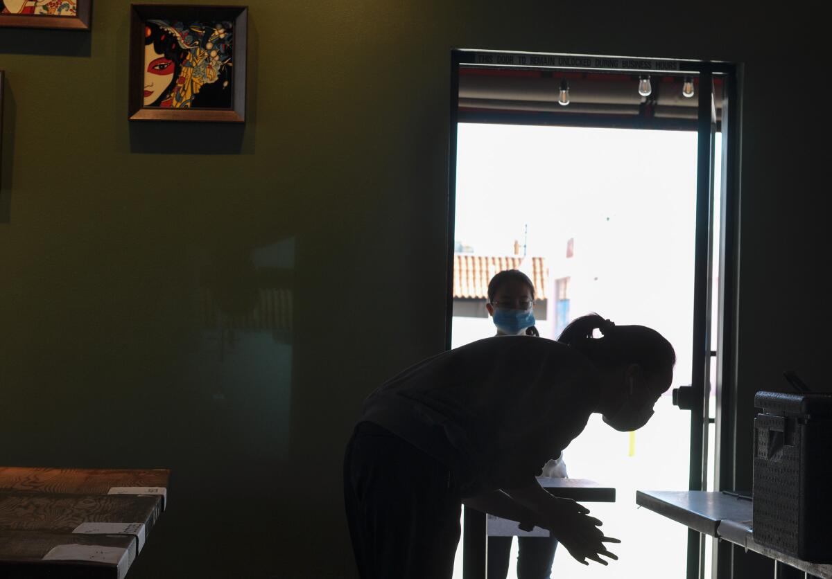 Customers wait for their takeout orders at Sichuan Impression in Alhambra. All staff have been wearing masks since January. 