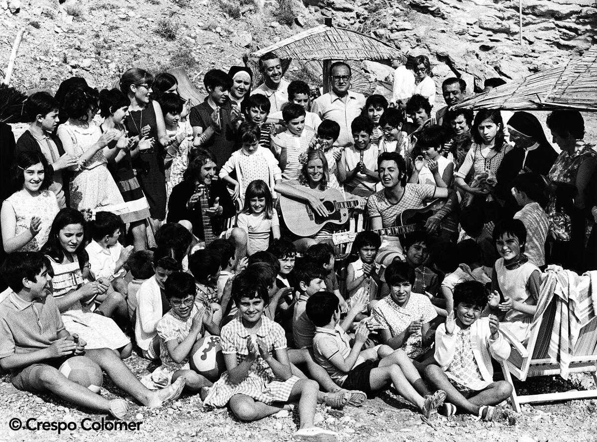 A black-and-white photo of Paul McCartney and Wings amid a group of young people